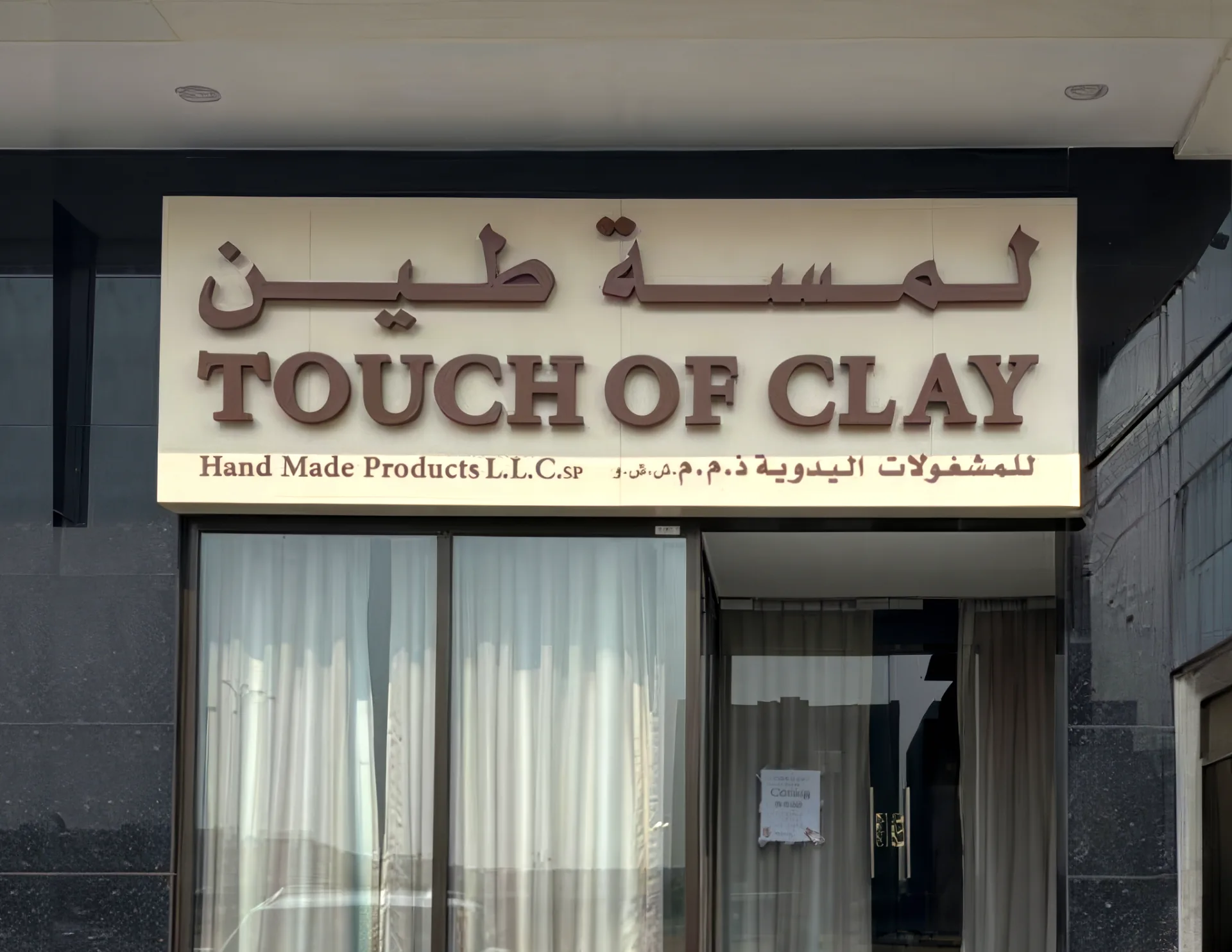 Brown 3D letters on a cream fascia for Touch of Clay